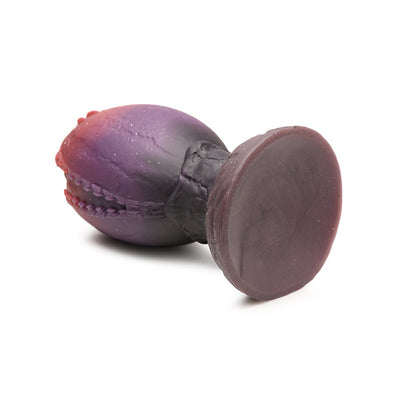 Purple and red dragon egg-shaped silicone plug with textured ridges and wide base on white background.