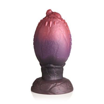 Dragon egg-shaped silicone plug with textured ridges and tapered dragon head tip in red and purple gradient colors.