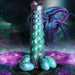Iridescent teal and purple segmented ovipositor dildo with textured bumps and four detachable egg-shaped accessories, set against a sci-fi alien landscape.