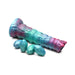 Iridescent teal, blue, and red segmented ovipositor dildo with textured surface and four detachable egg-shaped pieces on white background.