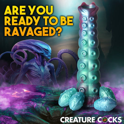 Iridescent teal and blue alien-inspired ovipositor dildo with textured shaft and four detachable egg-shaped accessories on a sci-fi landscape background.