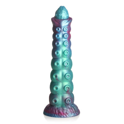 Iridescent teal, blue, and red textured ovipositor dildo with segmented shaft and wide base for harness compatibility.