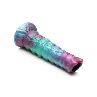 Iridescent teal, blue, and red textured ovipositor dildo with alien symbol and wide flared base on white background.