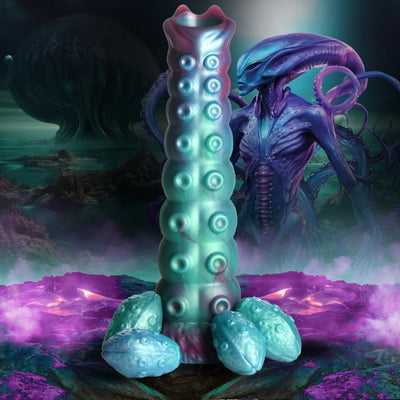 Iridescent teal and purple textured ovipositor dildo with four detachable egg-shaped pieces, set against a sci-fi alien landscape background.