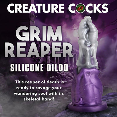Purple and silver Grim Reaper themed silicone dildo with skeletal hand design and wide suction base against a dark fantasy background.