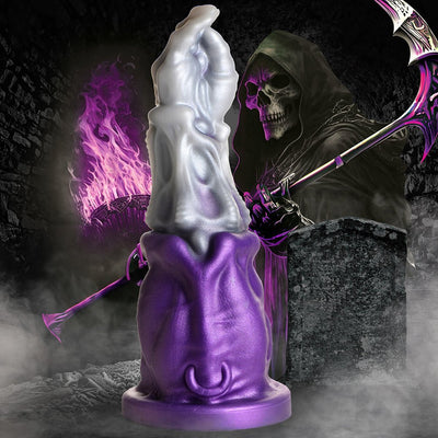 Purple and silver Grim Reaper-themed dildo with detailed hand design and wide suction base against dark, smoky background.