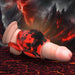 Red and black silicone girth enhancer with ball strap displayed on a realistic model against a fiery volcanic background.