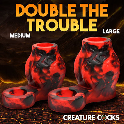 Red and black marbled silicone girth enhancers with ball straps in medium and large sizes on a volcanic background.