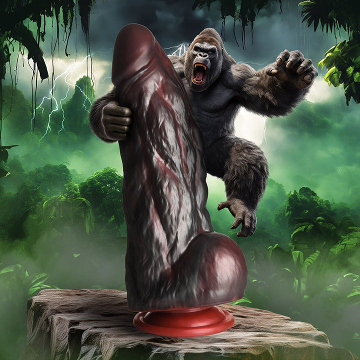 King Kong-themed silicone dildo with textured surface and suction cup base, set against a jungle storm background.