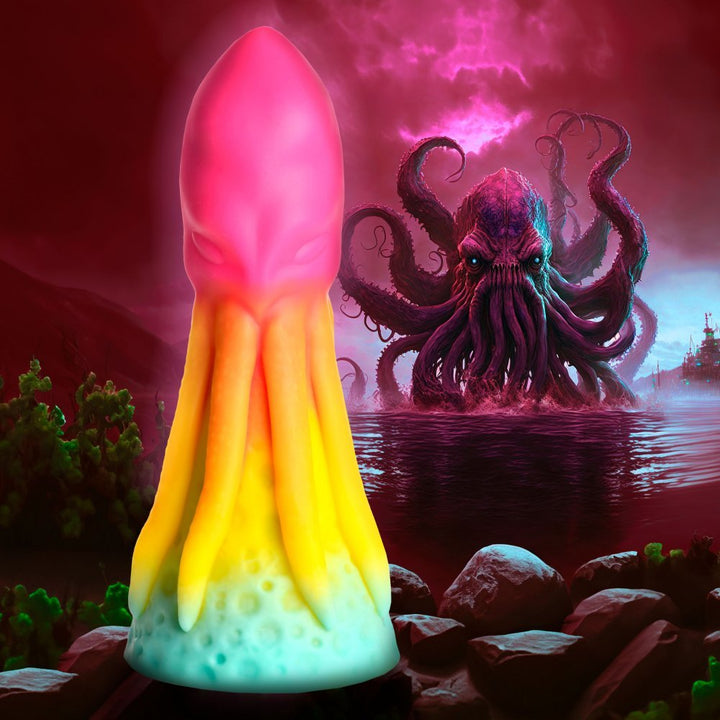 Rainbow-colored squid-shaped dildo with suction base against a dark ocean scene featuring a giant kraken.