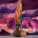 Orange and black marbled silicone fantasy tentacle dildo with textured ridges and suction cup base against stormy sky background.