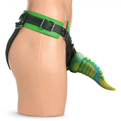 Side view of a mannequin wearing a green and black adjustable strap-on harness with a textured, tentacle-inspired dildo attached.