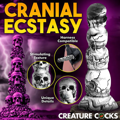 White and gray silicone dildo with skull designs, textured surface, suction cup base, and harness compatibility shown on purple background.