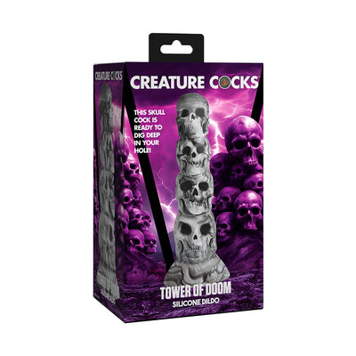 Packaging of Creature Cocks Tower of Doom silicone dildo featuring a stacked skull design on a purple lightning background.