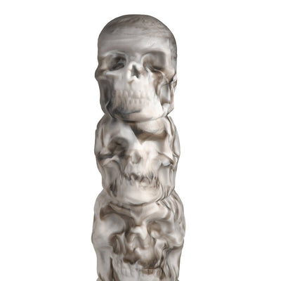 White and gray silicone dildo shaped as a vertical tower of detailed skulls with smoky shading effects.