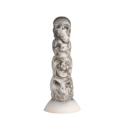 White and gray silicone dildo shaped as a tower of stacked skulls with a suction cup base.