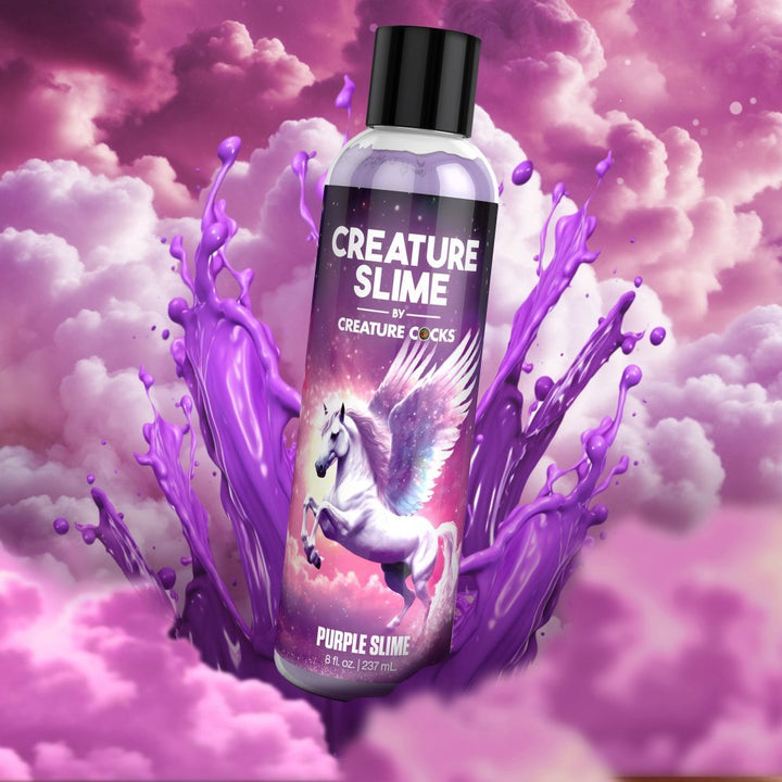Bottle of Creature Slime purple water-based lubricant with a winged unicorn on the label surrounded by splashing purple slime and pink clouds.