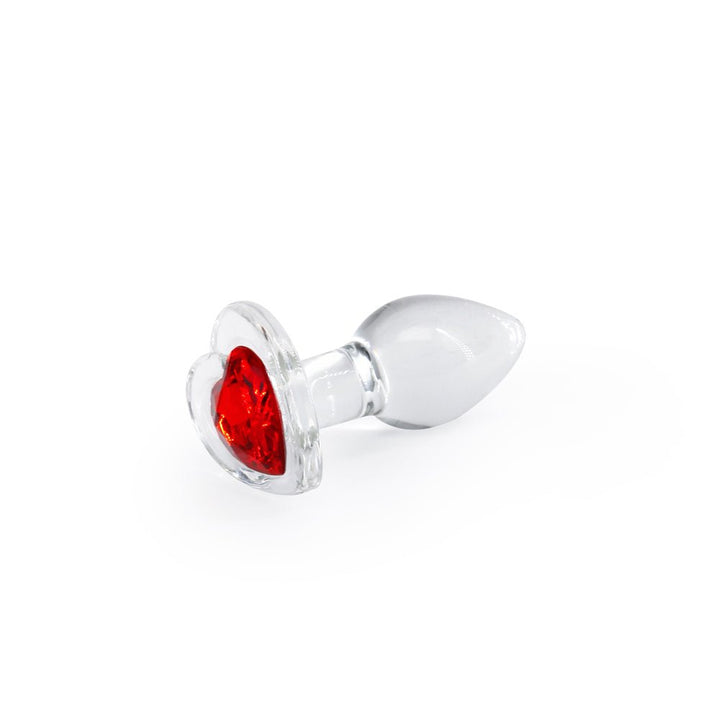 Small clear glass butt plug with a vibrant red heart-shaped gem base on a white background.