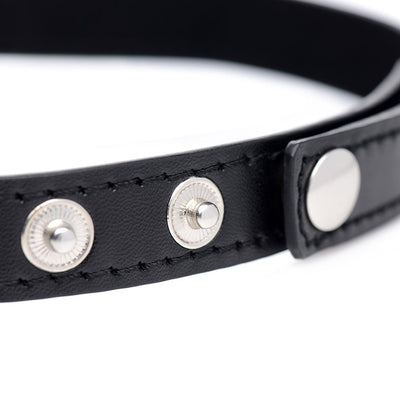 Close-up of black vegan leather choker strap with silver snap button closures and detailed stitching.