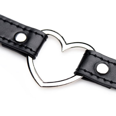 Close-up of black vegan leather choker with silver metal heart centerpiece and stitched detailing.