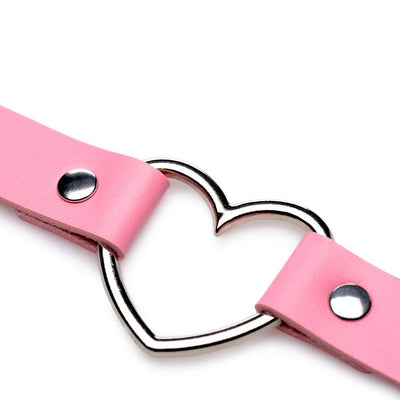 Close-up of pink vegan leather strap with silver metal heart-shaped ring and rivet details on white background.