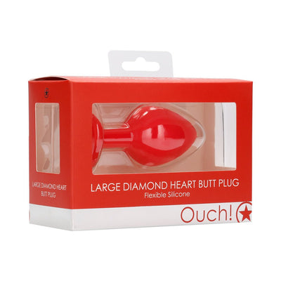 Large red silicone diamond heart-shaped butt plug in clear window box packaging with red and white design.