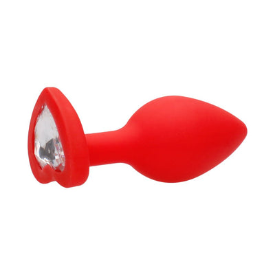 Large red silicone butt plug with heart-shaped clear gem at the base, smooth tapered design for comfort.