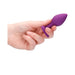 Hand holding a small purple silicone butt plug with a flared base and diamond detail.