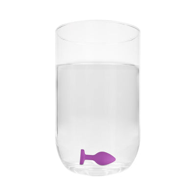Purple silicone diamond heart butt plug submerged in a clear glass of water showing waterproof feature.