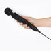 Hand holding a matte black Doxy Number 3 mains powered wand vibrator with control buttons and attached power cord.