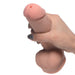 Hand holding a beige dual density squirting dildo with realistic texture and lifelike details.