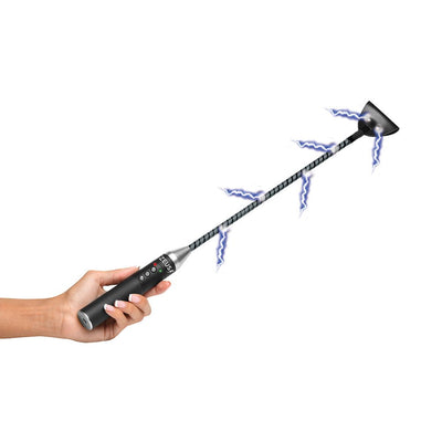 Hand holding a black e-stim crop with a flexible rod and conductive tip emitting electric sparks.