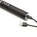 Close-up of a black rechargeable e-stim paddle handle with control buttons and a USB charging cable connected.