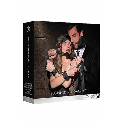 Box packaging of Ouch! Beginners Bondage Kit featuring a couple with bondage accessories including cuffs, ball gag, flogger, and eye mask.
