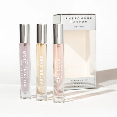 Set of three Eye of Love pheromone perfume sprays with sleek silver caps and elegant packaging.