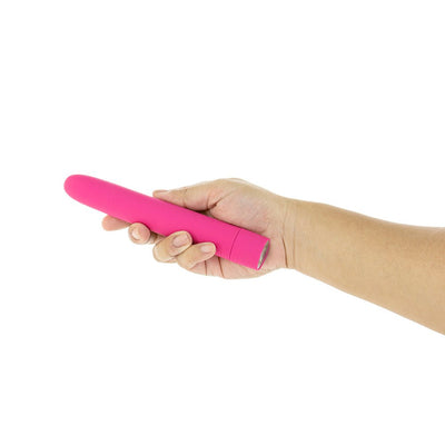 Hand holding a sleek pink silicone vibrator with a smooth finish against a white background.