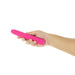 Hand holding a sleek pink silicone vibrator with a smooth finish against a white background.
