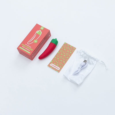 Chili Pepper shaped red and green vibrator with packaging, colorful instruction card, USB charging cable, and white storage pouch on white background.
