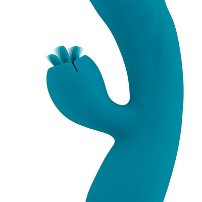 Close-up of blue silicone dual vibrator with flexible textured tongue flicker attachment on white background.