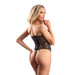 Blonde woman modeling black Art Deco lace underwire corset with lace-up back and matching G-string on white background.