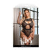 Plus size model wearing black barbed wire fishnet zippered bodysuit posing by a window and cage bars.