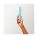 Hand holding a sleek, flexible blue Femme Funn Densa bullet vibrator with a textured purple base against a white background.