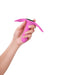 Hand holding a pink Femme Funn Ossia wearable vibrator with ergonomic flexible wings and textured grip.