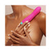 Close-up of a person holding a pink and teal FemmeFunn Rora rechargeable silicone rotating bullet vibrator against their shoulder.