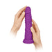Hands holding a purple, realistic textured silicone vibrator with a suction base.