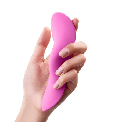 Hand holding a sleek, curved pink silicone vibrator with an ergonomic design against a white background.