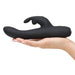 Hand holding a sleek black rechargeable slimline rabbit vibrator with curved shaft and clitoral stimulator.
