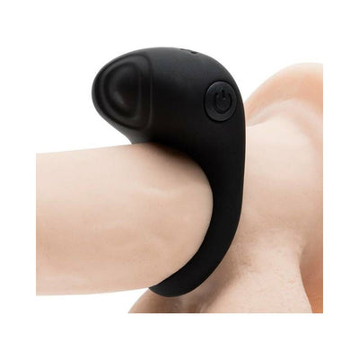Black rechargeable vibrating love ring with textured silicone pad and power button detail on a skin-toned model.