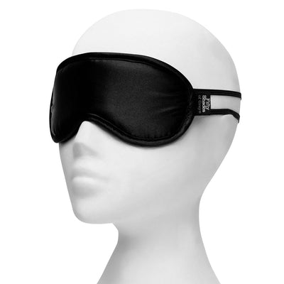 Black satin blindfold with Fifty Shades of Grey tag displayed on white mannequin head.