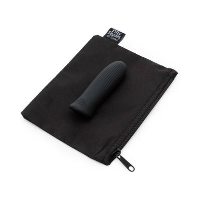 Black ribbed bullet vibrator resting on a black zippered storage pouch with Fifty Shades of Grey tag.